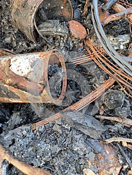 A photo of a pile of waste that traces its burning and over time rusts objects photo