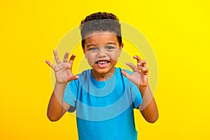 Photo of playful little child with curly hair dressed blue stylish t-shirt scare you hold hands up  on vibrant