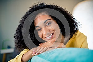 Photo of pleasant toothy beaming candid sincere woman with perming coiffure wear yellow long sleeve smiling on sofa at