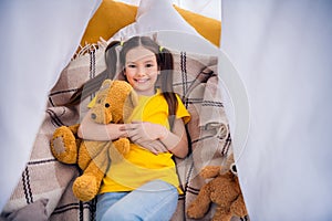 Photo portrait of adorable small girl lying floor tent hug plush toy dressed stylish yellow garment preschoolers