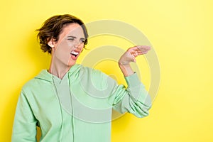 Photo portrait of adorable young woman irritated teasing talking hand blah dressed stylish green outfit isolated on