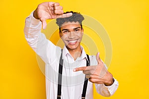 Photo portrait of african american man making frame with fingers  on vivid yellow colored background