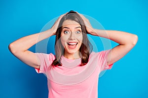 Photo portrait of amazed happy girl with brunette hair smiling opened mouth touching head hands isolated on vibrant blue