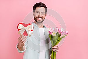 Photo portrait of attractive young man giftbox bouquet tulips valentine day dressed stylish blue outfit isolated on pink