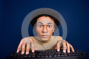 Photo portrait of attractive young man typing keyboard dressed stylish beige clothes isolated on dark blue color