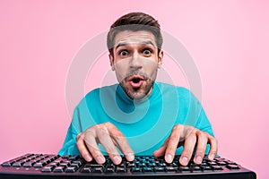 Photo portrait of attractive young man writing typing computer gamer dressed stylish blue clothes isolated on pink color