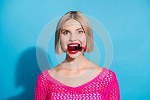 Photo portrait of attractive young woman bite red pomade crazy dressed stylish pink knitwear clothes  on blue