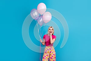 Photo portrait of attractive young woman hold amazed air balloons dressed stylish pink clothes isolated on blue color
