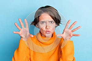 Photo portrait of attractive young woman raise hands frighten boo funky fooling wear trendy orange look isolated on blue