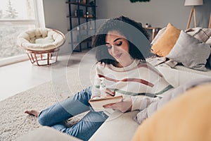 Photo portrait of attractive young woman sit floor hold copybook dressed casual clothes cozy day light home interior