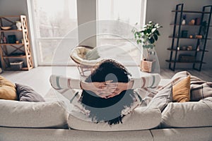 Photo portrait of attractive young woman sit sofa hands behind head sleepy dressed casual clothes cozy day light home