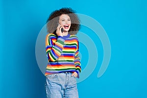 Photo portrait of attractive young woman talking phone friend laugh wear trendy rainbow print clothes isolated on blue