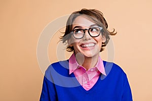 Photo portrait of attractive young woman toothy smile look empty space wear trendy blue clothes isolated on beige color