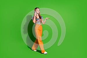 Photo portrait of attractive young woman walk talk phone dressed stylish retro clothes isolated on green color