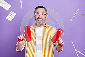 Photo portrait bearded man smiling keeping gun shot dollars money isolated pastel violet color background