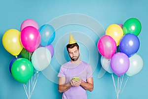 Photo portrait of bored guy writing sms because nobody came to birthday party holding phone in two hands isolated on