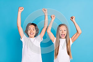 Photo portrait boy girl smiling gesturing like winners happy isolated pastel blue color background