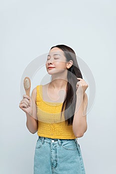 Photo portrait brunette woman showing wooden brush smiling isolated white color background