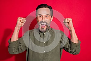 Photo portrait businessman wearing green shirt gesturing like winner isolated bright red color background