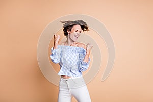 Photo portrait of crazy celebrating girl screaming isolated on pastel beige colored background