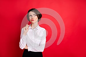 Photo portrait of curious business woman keeping glasses thoughtful looking copyspace isolated bright red color