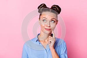 Photo portrait of curious dreamy young woman wearing shirt looking blank space touching face isolated on pastel pink