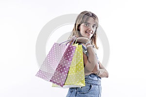 Photo portrait of cute young girl holding shopping bags isolated on blue color background