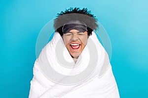 Photo portrait of cute young guy excited closed eyes soft cover wrapped blanket isolated on blue color background