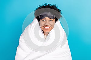 Photo portrait of cute young guy toothy beaming smile soft cover wrapped blanket isolated on blue color background