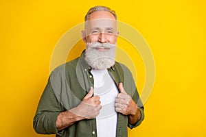 Photo portrait of elder man smiling wearing green shirt isolated vivid yellow color background