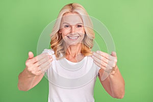 Photo portrait elder woman smiling showing come on sign happy isolated pastel green color background