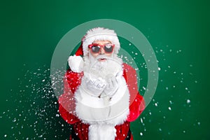 Photo portrait of elderly retired man hands blow air snowy wear trendy santa claus costume coat isolated on green color