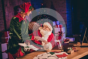 Photo portrait of elf giving santa claus paper letter