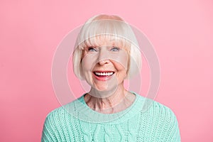 Photo portrait of excited aged woman wearing teal knitted sweater blonde hair staring smiling isolated on pastel pink