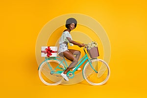 Photo portrait full body side view of bicycle rider delivering big white present isolated on vivid yellow colored