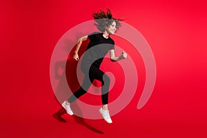 Photo portrait full body view of girl running jumping up isolated on vivid red colored background