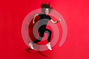 Photo portrait full body view of woman running jumping up isolated on vivid red colored background