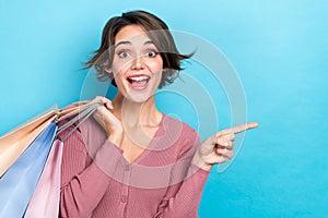 Photo portrait of funny surprised girl pointing finger empty space new black friday shopping offer isolated on blue