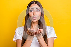 Photo portrait girl brown hair white t-shirt sending air kiss on date isolated vivid yellow color background