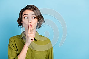 Photo portrait of girl keeping secret put finger near lips showing sign to be silent looking at side wearing formal