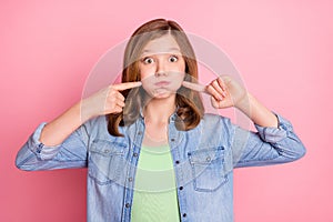 Photo portrait girl playful holding air in cheeks  pastel pink color background