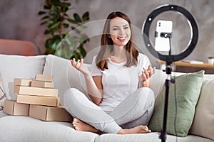 Photo portrait girl smiling doing wideo blog sitting on sofa near carton boxes photo