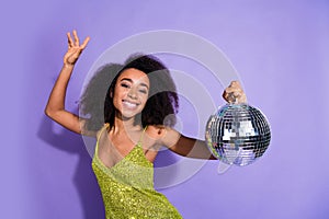 Photo portrait of gorgeous young girl dancing hold discoball wear trendy green sequins outfit isolated on purple color