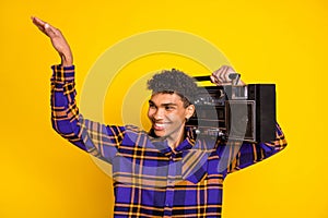 Photo portrait of handsome guy smiling keeping retro tape recorder looking empty space dancing isolated on vibrant
