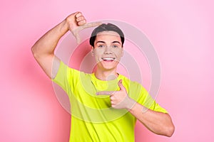 Photo portrait of handsome teen male fingers show photo frame cadre wear trendy yellow garment isolated on pink color