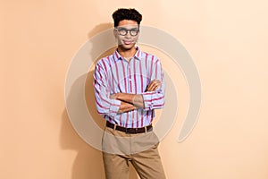 Photo portrait of handsome young male folded arms specialist wear trendy striped formalwear outfit isolated on beige