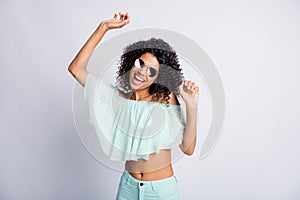 Photo portrait of happy cheerful mulatto girl with curly hairstyle wearing sunglass mint outfit dancing isolated on grey