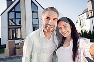 Photo portrait of happy family couple wife husband smiling outdoors new home after moving relocating