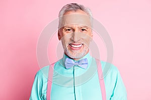 Photo portrait of happy smiling old man wearing nice shirt bowtie and suspenders isolated on pink color background