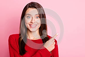 Photo portrait of happy surprised brunette girl smiling pointing on empty space with finger wearing knitted sweater